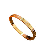 Close-up of Double C 3D engraved gold-plated open bracelet design