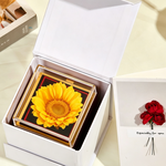 Bloom and Forever Eternal Sunflower Jewelry Drawer Box open inside a white outer gift box, showing a vibrant yellow preserved sunflower displayed under a clear acrylic lid on a black base with a red accent border, with an Especially for You greeting card beside it on a cream surface