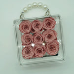 Close-up of petite eternal pink rose in acrylic handbag gift box
