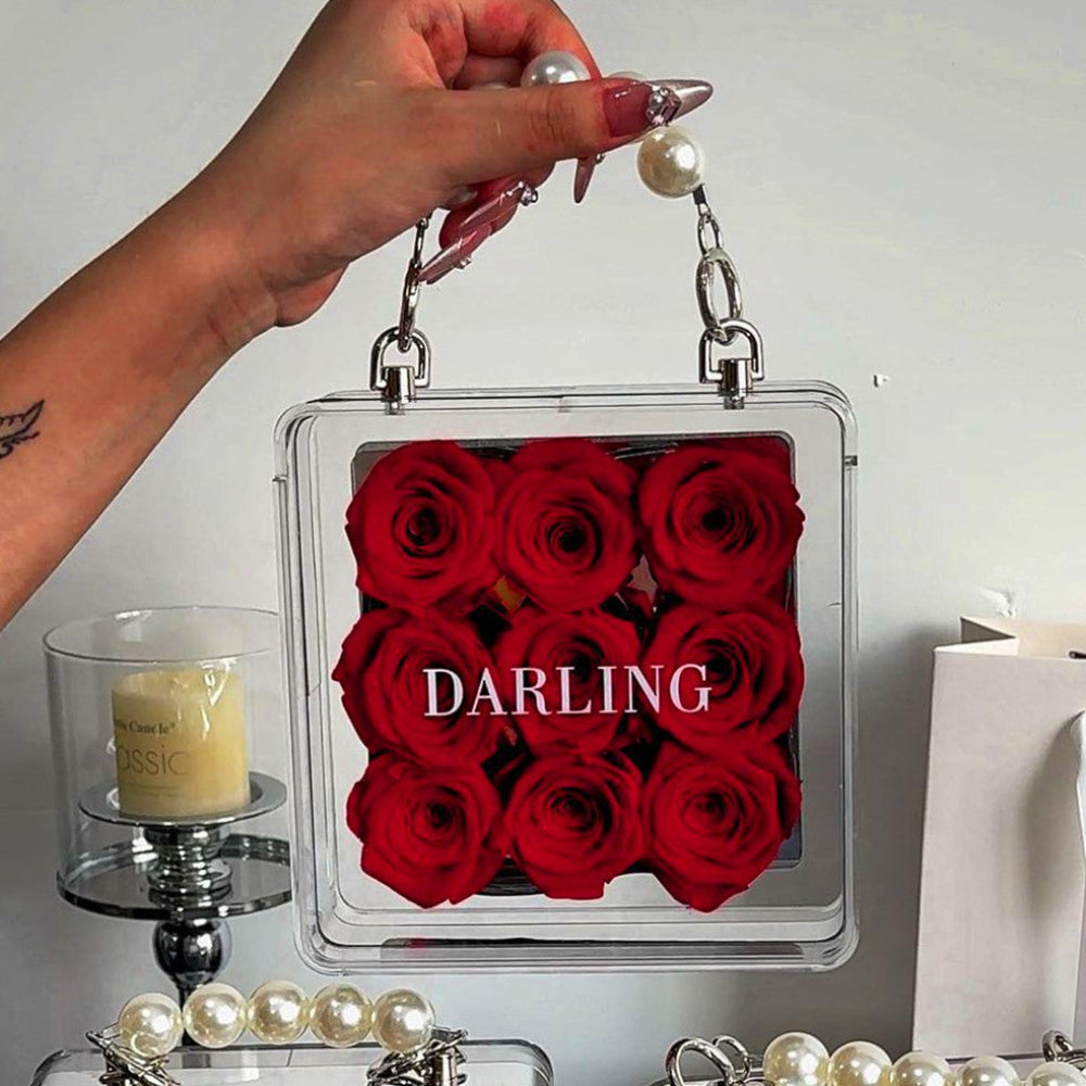 Petite eternal red rose in acrylic handbag gift box held in hand