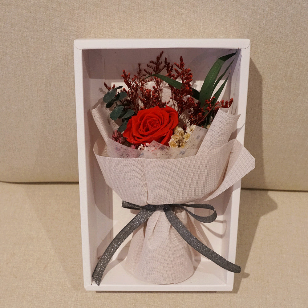 Close-up of petite eternal red rose bouquet – Fairy Light Edition